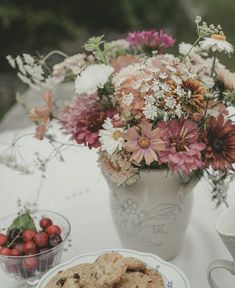 a white table topped with cookies and flowers