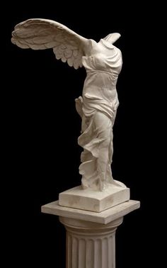 a white statue with wings on top of a pedestal