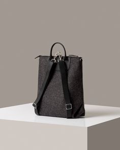 The Bedford Backpack's unique three-way design shows off the sculptural quality of felt as well as Merino wool felt's natural durability. Detachable straps convert the Bedford from backpack (https://graflantz.com/collections/backpack) to shoulder tote in seconds. Features include an interior zippered felt pocket, smooth leather trim, and nickel hardware.

 Also available in a mini (https://graf-lantz.com/products/bedford-backpack-mini-granite-felt-sienna-leather) version for a smaller frame or lighter load

 To add a little extra flare and make your bag even more unique, why not add one of our Fobs (https://graflantz.com/collections/keychains).

 
*Please Note: Gift Boxes are not available for this item



 Benefits of Merino Wool Felt

  
 * Sustainable, biodegradable, and renewable 
 * O Modern Backpack With Leather Trim For On-the-go, Business Backpack With Leather Trim, Modern Backpack With Leather Trim, Modern Business Backpack With Leather Handles, Everyday Leather Trim Backpack, Everyday Backpack With Leather Trim, Commuting Backpack With Leather Trim, Functional Leather Trim Backpack For Daily Use, Modern Backpack With Leather Handles