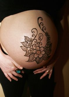 a pregnant woman's belly with an intricate design on it, showing her stomach