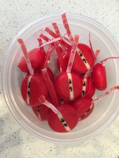 a bowl filled with red heart shaped candies on top of a white countertop