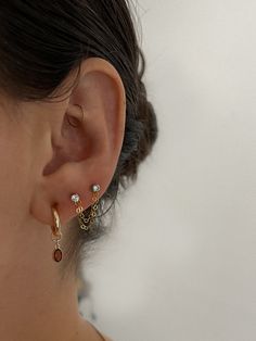 a close up of a person wearing some kind of earring with two different colored stones