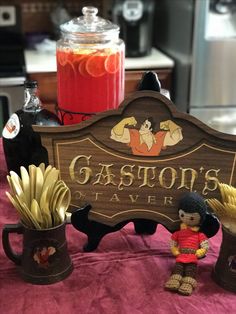 a wooden sign sitting on top of a table next to two vases filled with food