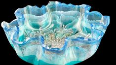 a blue and white glass bowl on a black background