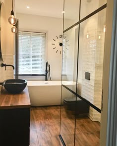 a bathroom with a tub, sink and large mirror in it's center wall