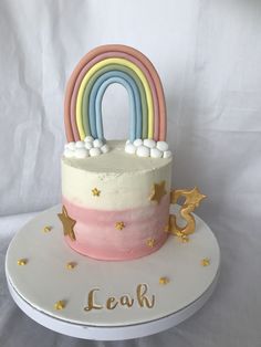 a rainbow cake with white frosting and gold stars