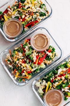 three plastic containers filled with salads and dressing on top of a white countertop