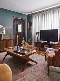 a living room filled with furniture and a flat screen tv sitting on top of a wooden table