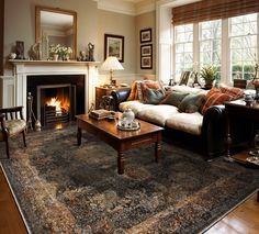 a living room filled with furniture and a fire place in the middle of a room