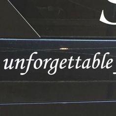 the word unforgettableable is written in white ink on a black surface