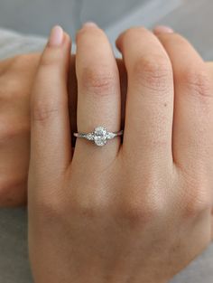 a woman's hand with a diamond ring on top of her finger and an engagement band