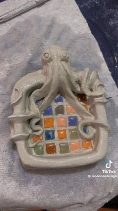 an octopus figurine sitting on top of a piece of glass in front of a towel