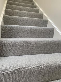 carpeted stairs leading up to the second floor in a home with white walls and gray carpet