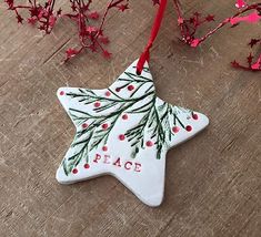 an ornament shaped like a star with the word peace hanging from it's side