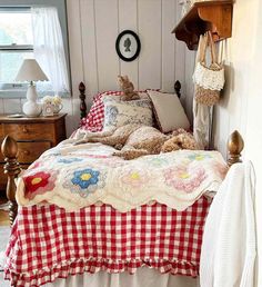 a bed with a red and white checkered bedspread on top of it