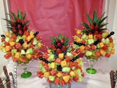 two vases filled with fruit on top of a table