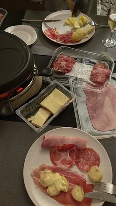 meat and cheeses are on plates next to an air fryer