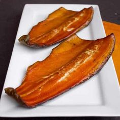 two pieces of fish on a white plate