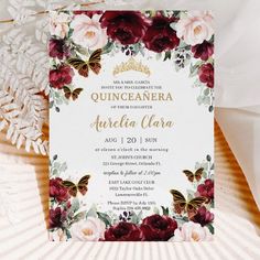 a wedding card with flowers and butterflies on the front, sitting next to a fan