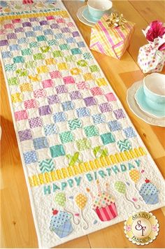 a table runner with tea cups and plates on it