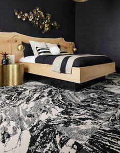 a black and white bedroom with gold accents on the headboard, bed frame and rug