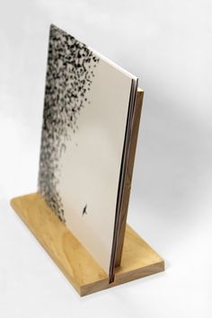 an open book on a wooden stand with black ink splatters all over it