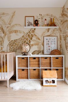 a baby's room with a giraffe wallpaper and baskets on the floor