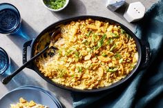 a casserole dish with rice and vegetables in it on a blue table cloth