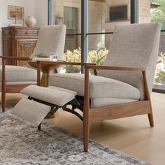 a living room with two chairs and a rug in front of the glass door that leads to an outside patio