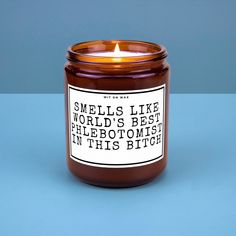 a candle with a label on it sitting on a blue surface next to a wall