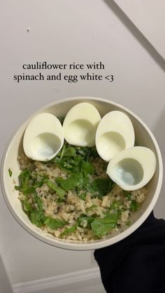 a person holding a bowl filled with rice and hard boiled eggs