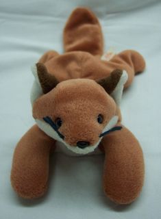 a brown stuffed animal laying on top of a white sheet