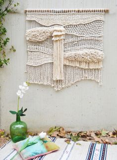 an image of a wall hanging made with macrame yarn and flowers in a vase