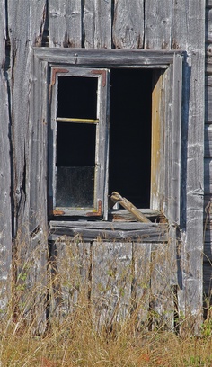 an old wooden building with a broken window