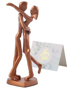 a bronze figurine with a card in front of it that says love you