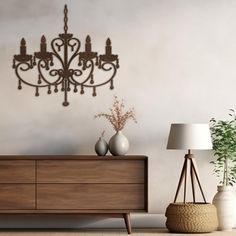 a chandelier hanging from the side of a wall next to a dresser and lamp