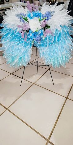 an arrangement of blue and white flowers on a table