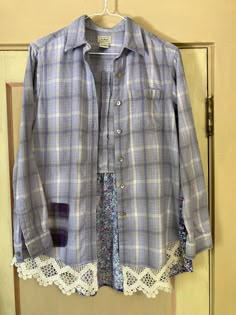 a blue and white plaid shirt hanging on a door with lace around the bottom half