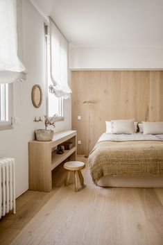 a bedroom with wood paneling, white walls and wooden floors is pictured in this image