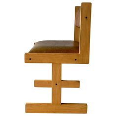 a wooden chair with a leather seat and back rest on it's legs, against a white background