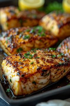 grilled fish on a pan with lemons and parsley