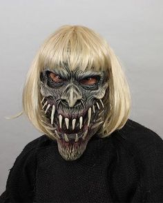 a woman with long blonde hair wearing a creepy mask