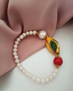 Sicilian bracelet made of: - Freshwater Pearls (6 mm), white color; - Sicily Ceramic Lemon (30 mm x 16 mm); - Mallorca Pearl (12 mm), white color; - Mallorca stone (12 mm), red color. * SHIPPING * Your order will be shipped within 1-3 business days from your purchase. You can choose between 2 shipping methods: STANDARD MAIL (NOT TRACEABLE) It is a cheap and fast shipping method, but NOT TRACEABLE. Chapeau Atelier is not responsible for any postal disruptions, delays or losses. REGISTERED MAIL (T White Single Strand Beaded Bracelet For Gift, White Single Strand Round Bracelet, White Single Strand Bracelet As A Gift, White Round Single Strand Bracelet, White Single Strand Bracelet Gift, Classic White Pearl Bangle Bracelet, Classic White Bracelet As A Gift, Classic White Bracelet For Gift, Classic White Bracelet For Gifts