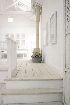 a white room with stairs and pictures on the wall