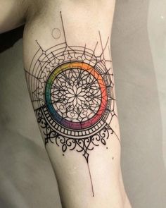 a woman's leg with a colorful tattoo on the side of her arm and an intricate