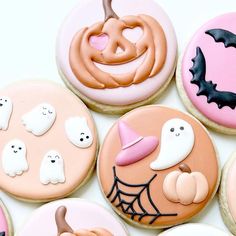 some decorated cookies are sitting on a white surface with bats, pumpkins and jack - o'- lanterns