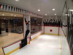 an ice rink with hockey players on the sidelines and flags hanging from the ceiling