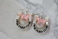 This listing is for one pair of made to order Chappell Roan inspired pink pony earrings. Designed from scratch by me, these are made acrylic in hues of opalescent pearl and baby pink. They measure about 2.5" in total length, and have stainless steel posts. If you would prefer gold hardware, or with fishhooks or leverbacks, please just let me know at checkout and I can make them to fit your needs! These earrings will be made and shipped to you within a week of your order. Playful Personalized Pink Earrings, Novelty Personalized Pink Earrings, Personalized Pink Novelty Earrings, Fun Personalized Pink Earrings, Pink Pony Club, Baby Rosa, Pony Club, Chappell Roan, Love Jewelry