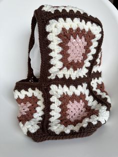 a brown and white crocheted bag sitting on top of a white plate