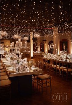 a banquet hall with tables, chairs and chandeliers on the ceiling is lit by lights